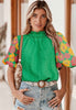 Front view of Melania top. Green with floral puff sleeve. 